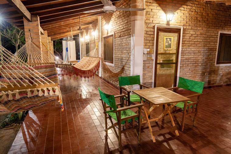 Corredor de la Cabaña Santa Rita con hamacas paraguayas y mesa